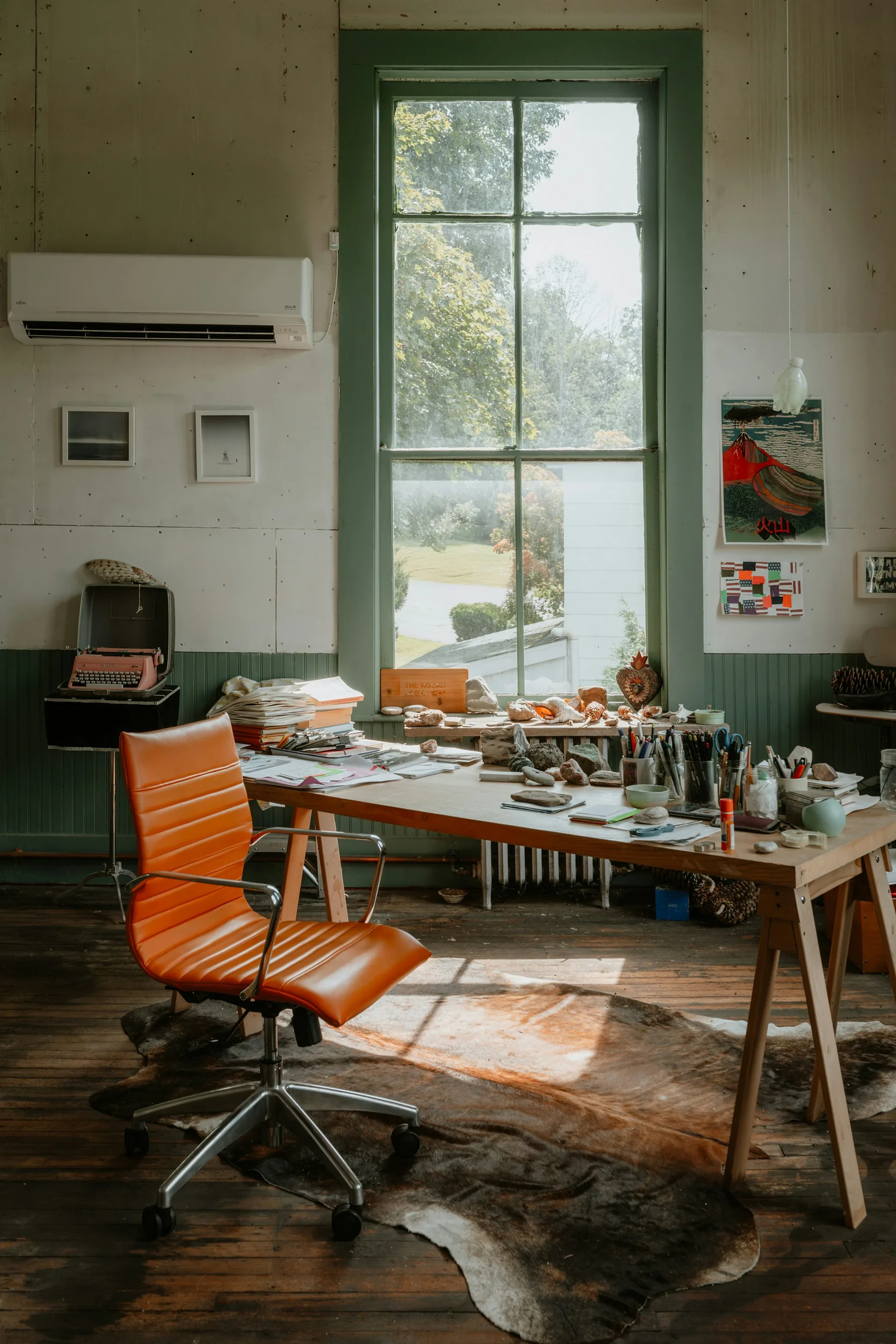 Independent artist studio with a large worktable and orange chair